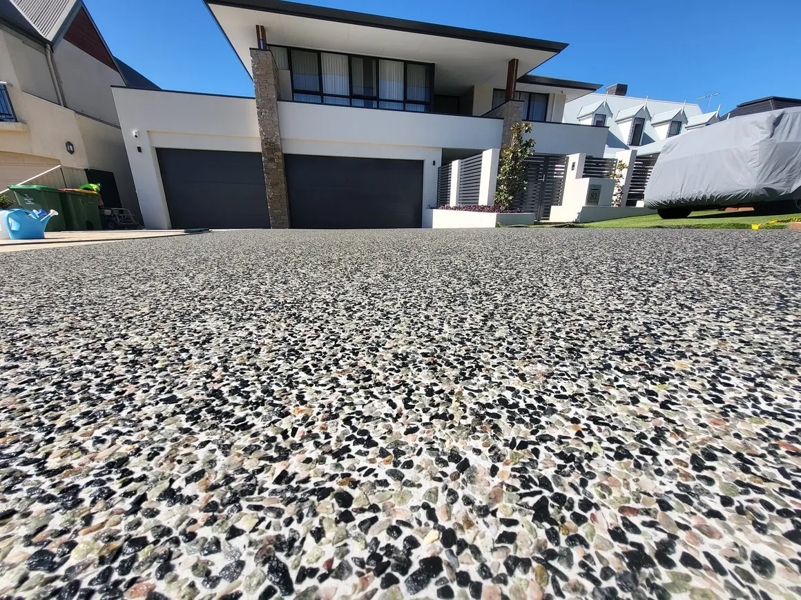 A close-up of an exposed aggregate concrete patio finish