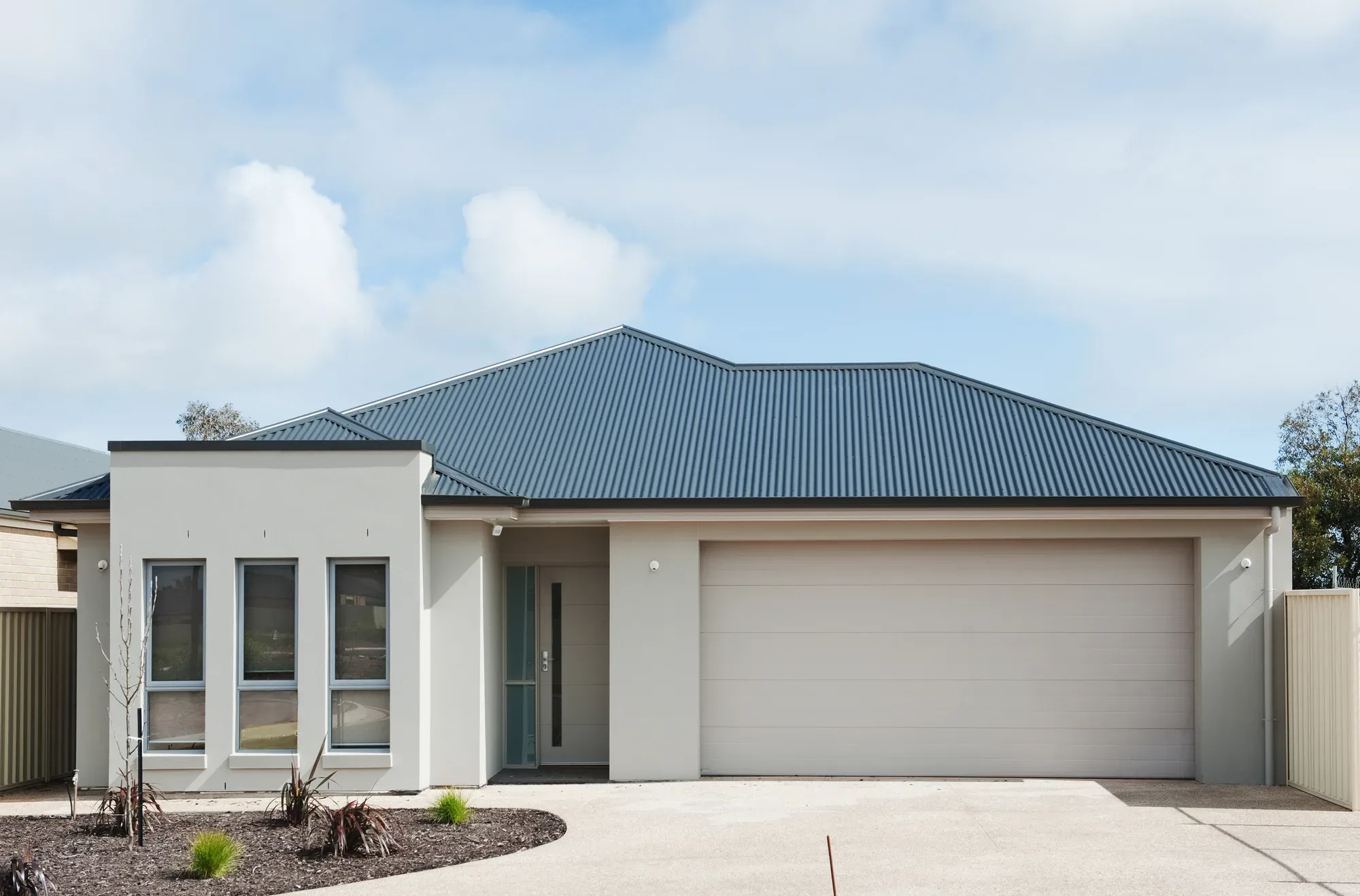 A finished plain concrete driveway leading to a home in the Liverpool area